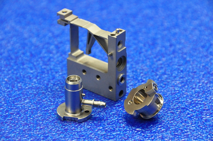 Precision-machined components displayed on a blue surface