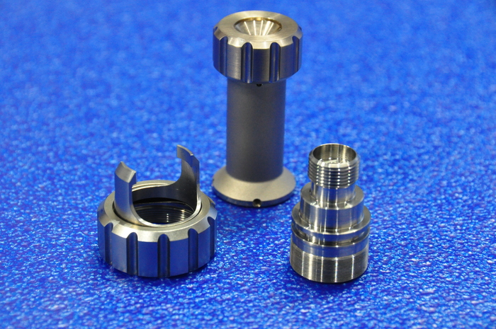 Precision-machined cylindrical components displayed on a blue surface